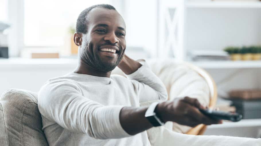 man watching TV with remote