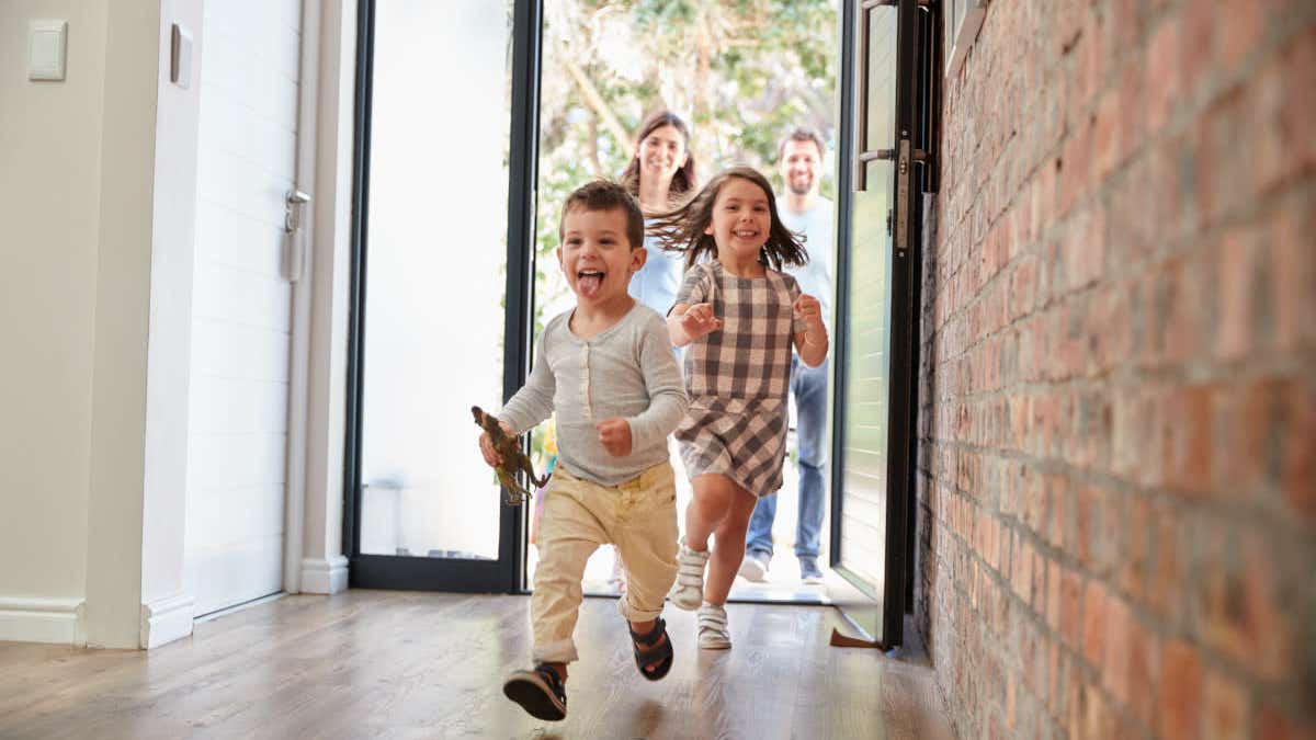Child running through the front door of new home ahead of his family