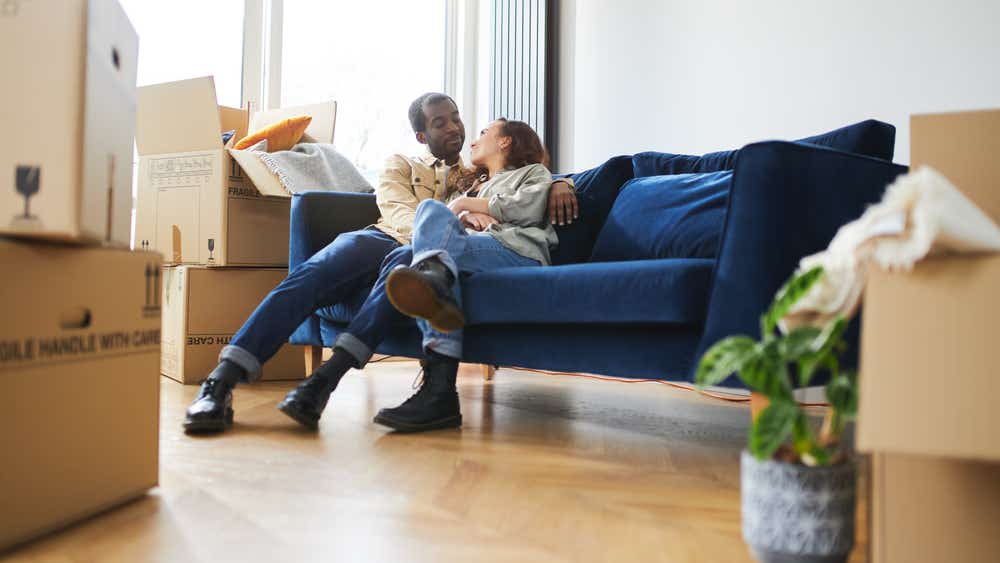 Young couple surrounded by boxes after porting their mortgage
