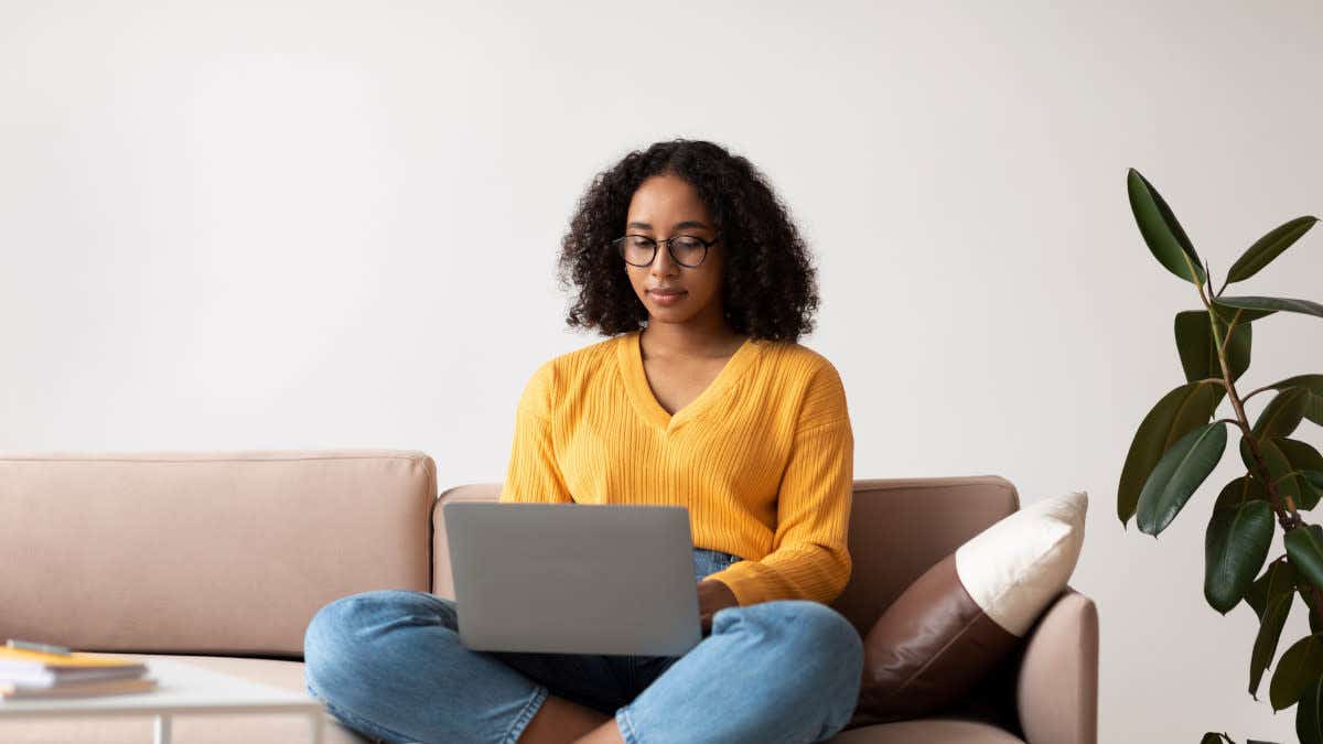 Woman sitting cross-legged on sofa