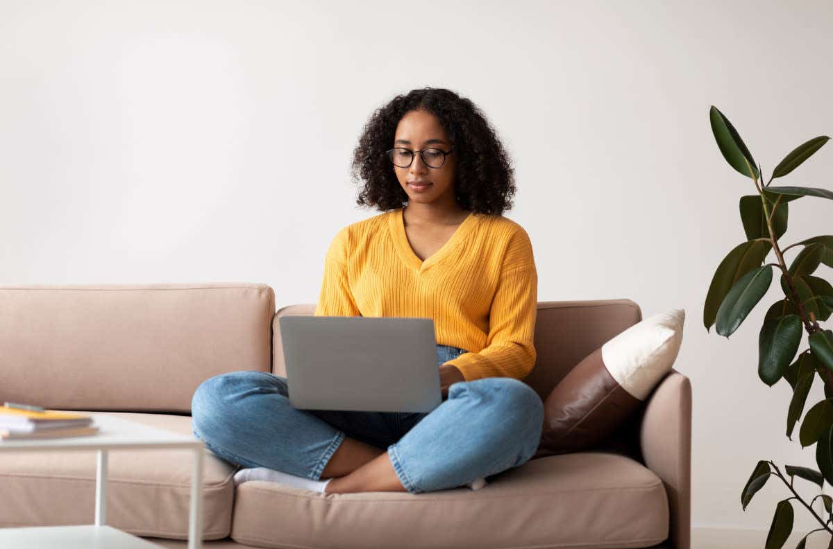 Woman sitting cross-legged on sofa