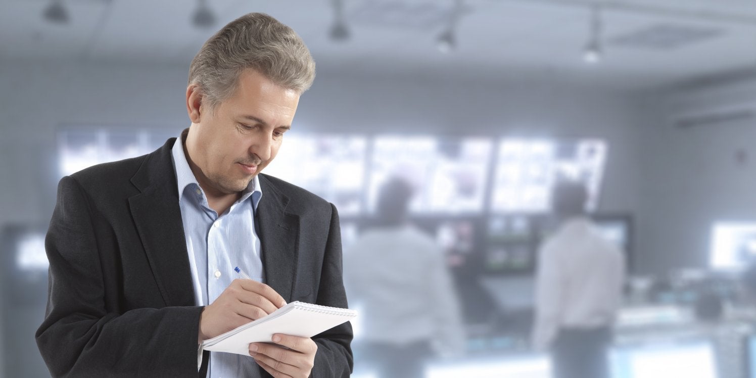 Man writing notes on notepad