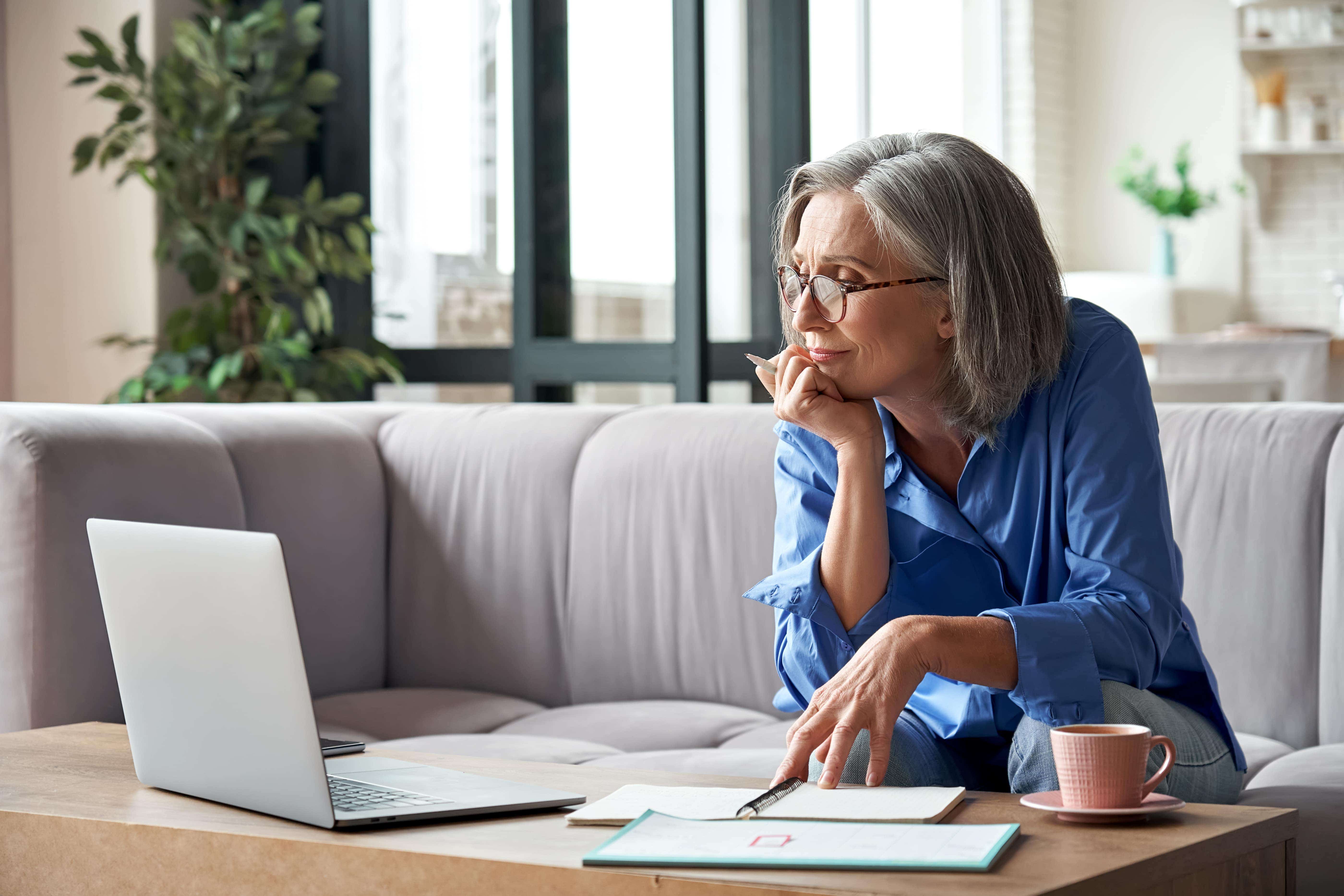 Woman looking at a laptop assessing finances