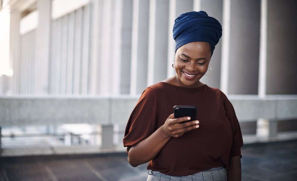 Women holding mobile phone and smiling