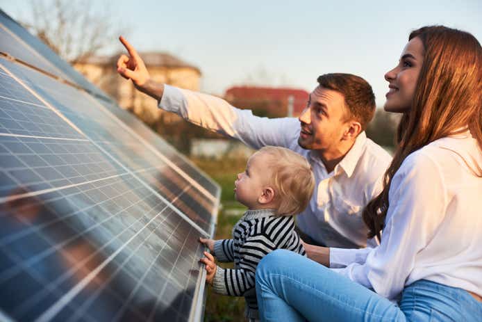 Family looking at their low carbon solar panels