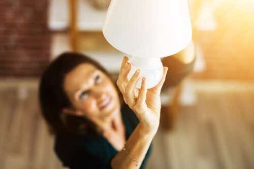 Woman screwing in new energy-efficient lightbulb