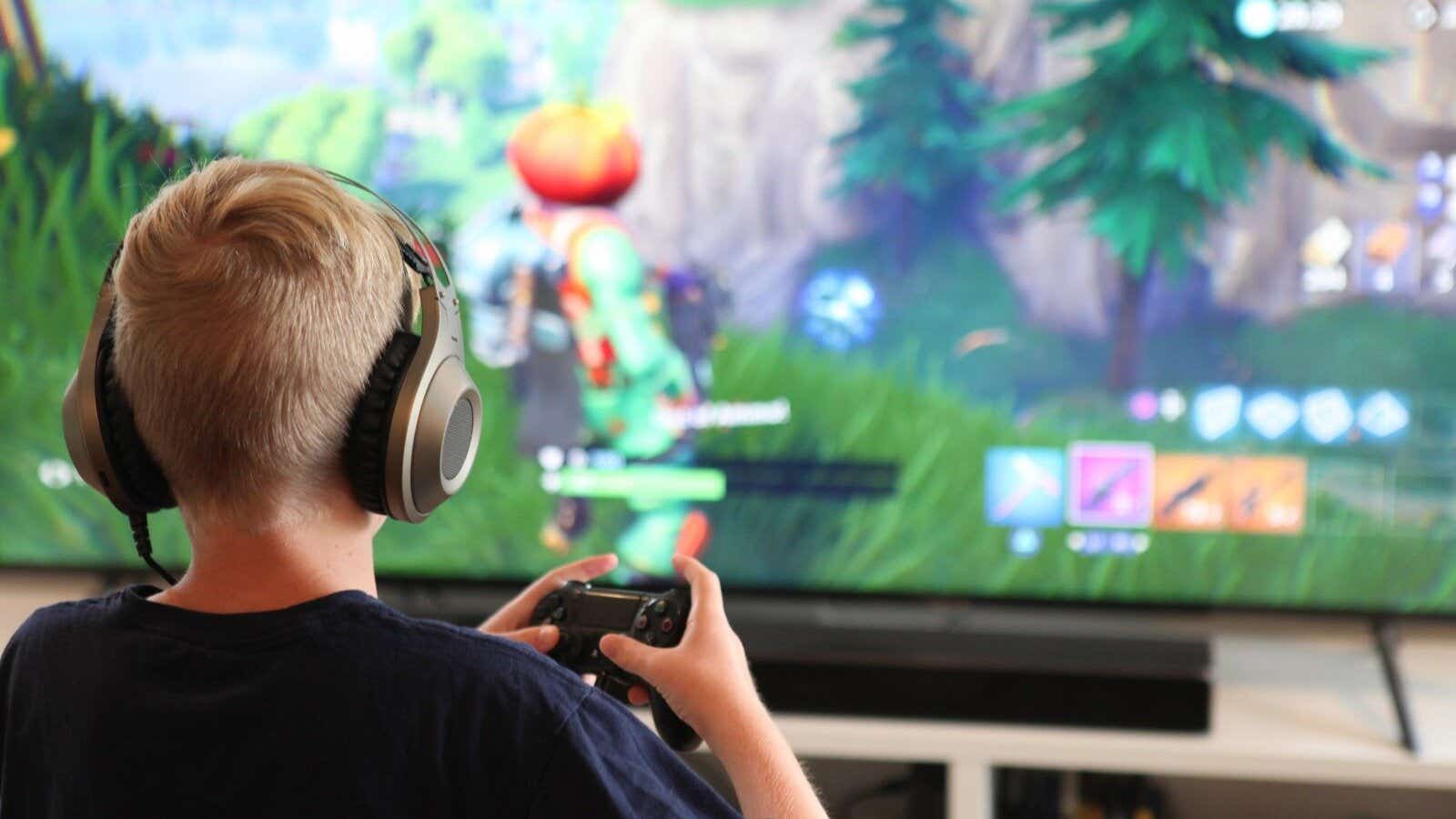 kid playing video games large screen tv