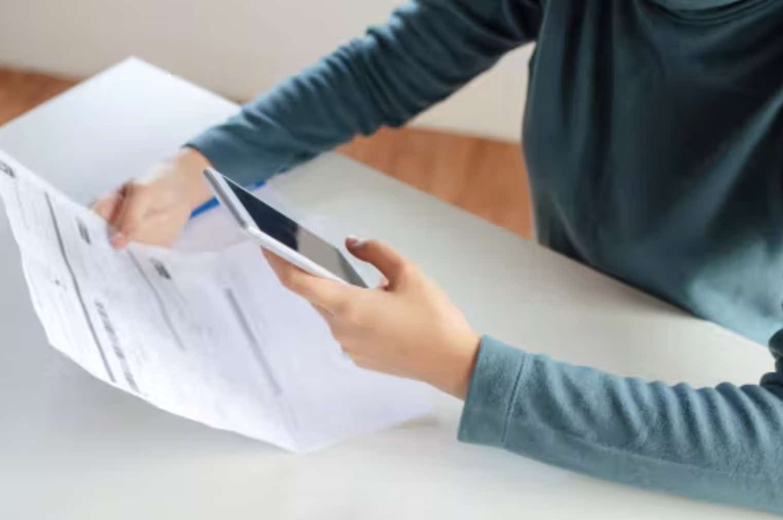 Man looking at bill with phone