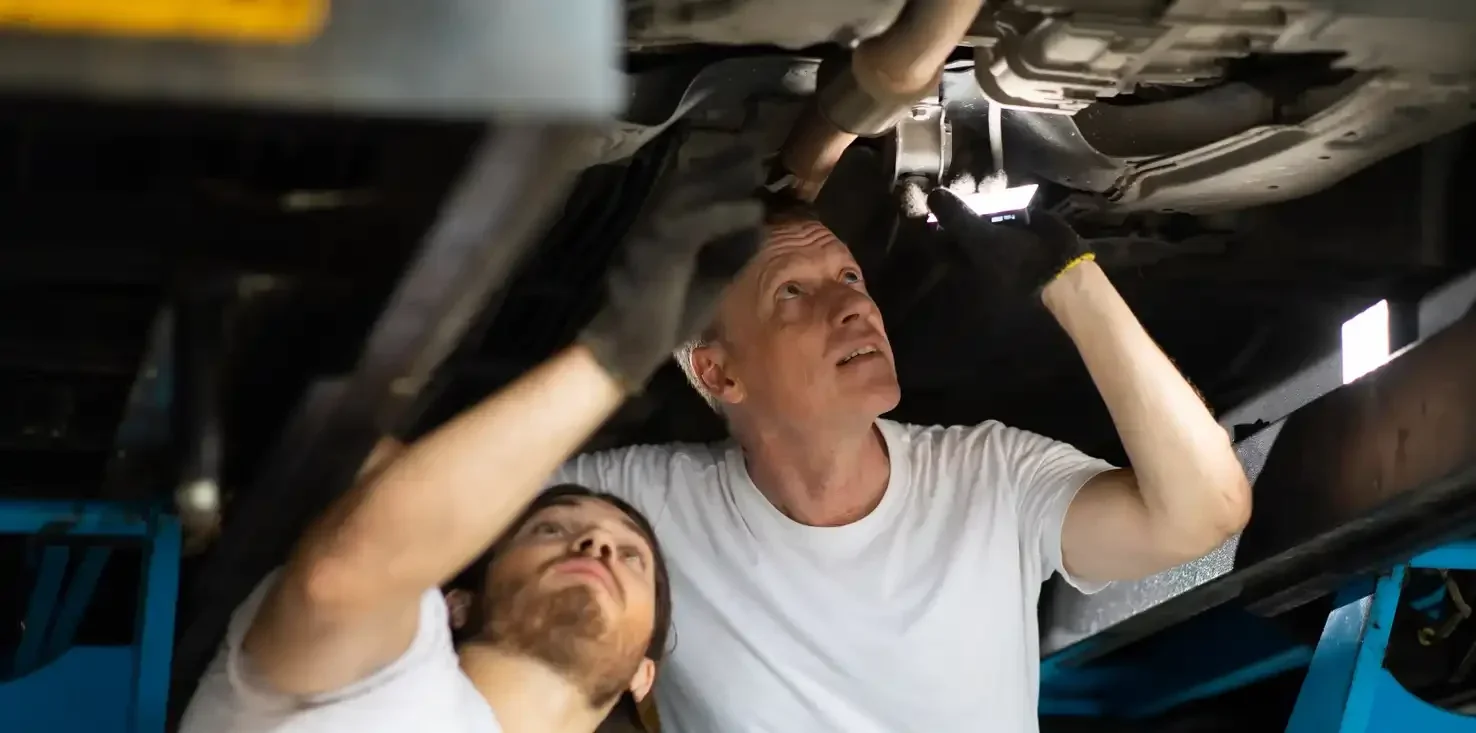 Two men fixing a car