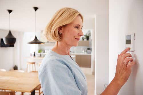 Woman adjusting central heating on wall