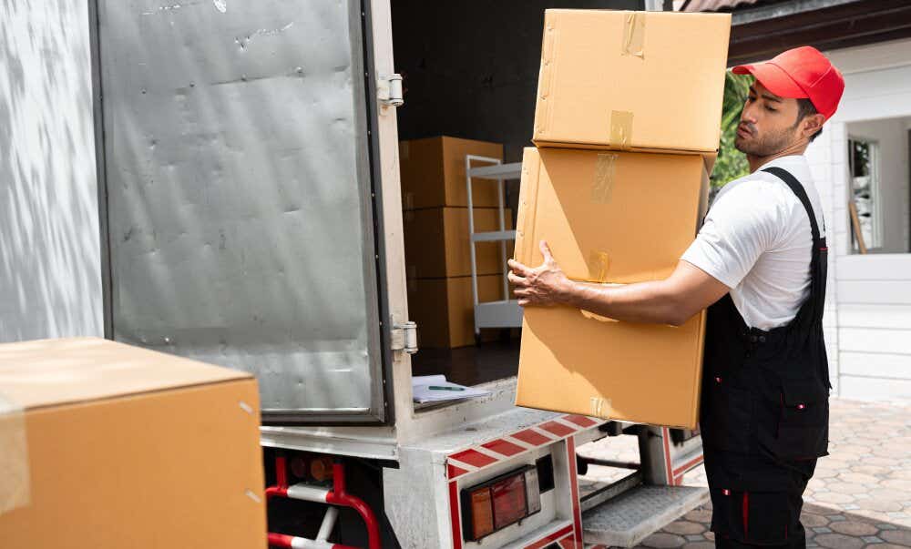 An image of a removal professional loading boxes into a removal van.