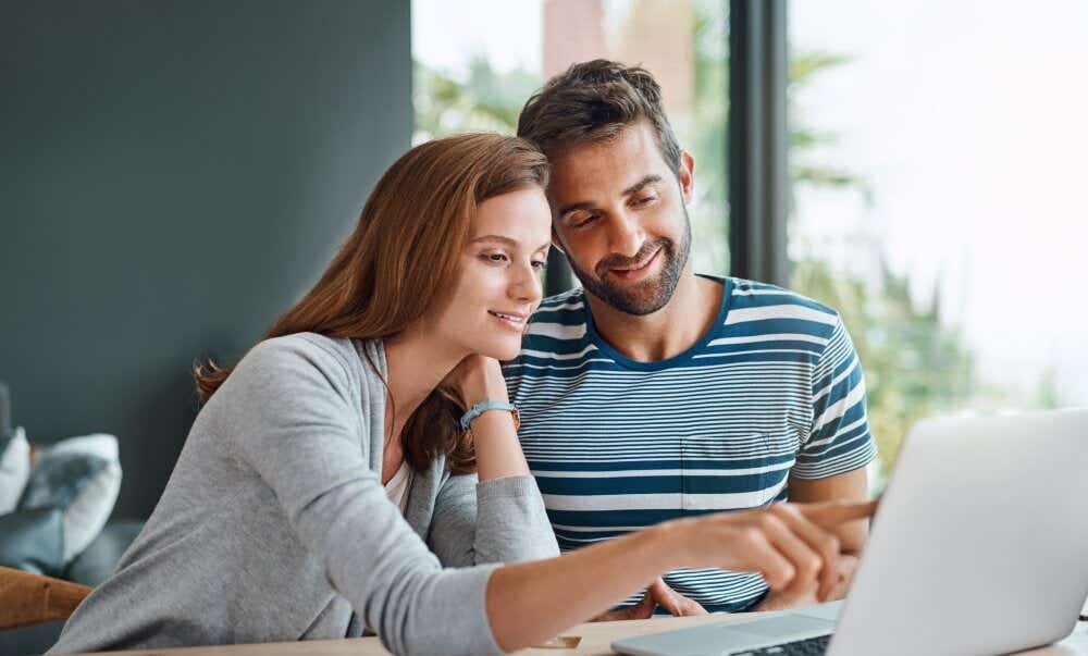 An image of a couple researching on a laptop together at home.