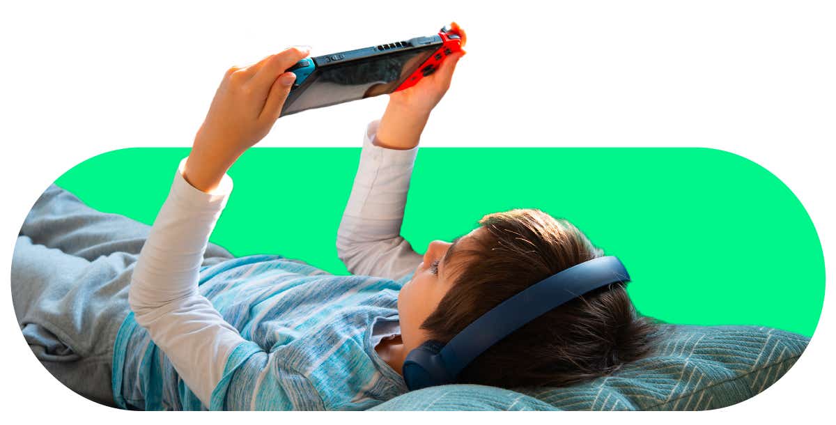 An image of a young boy with headphones playing on a Nintendo Switch.