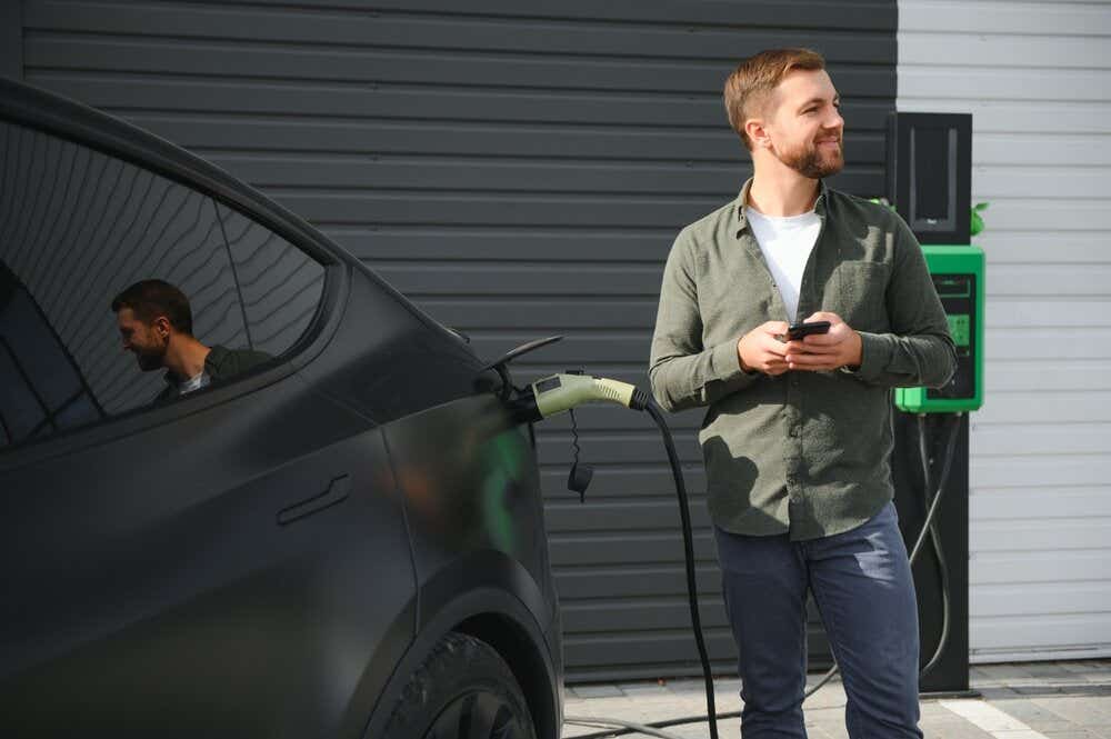 Woman charging her yellow car in front of her house