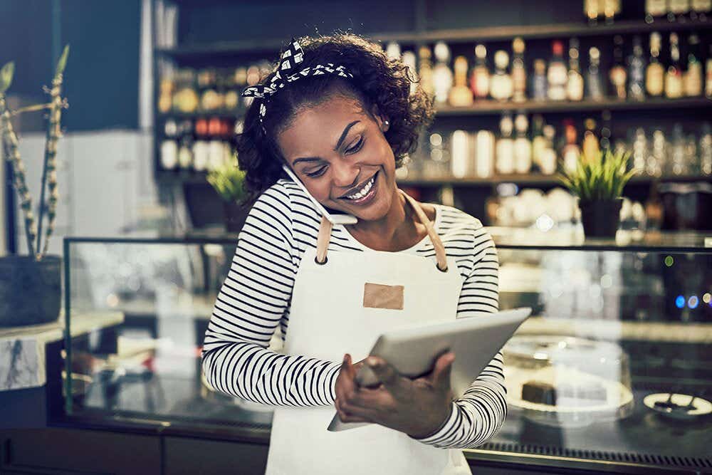 Woman on phone looking at tablet