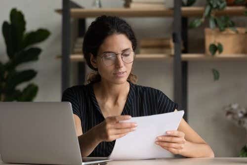 Woman reading bill with laptop