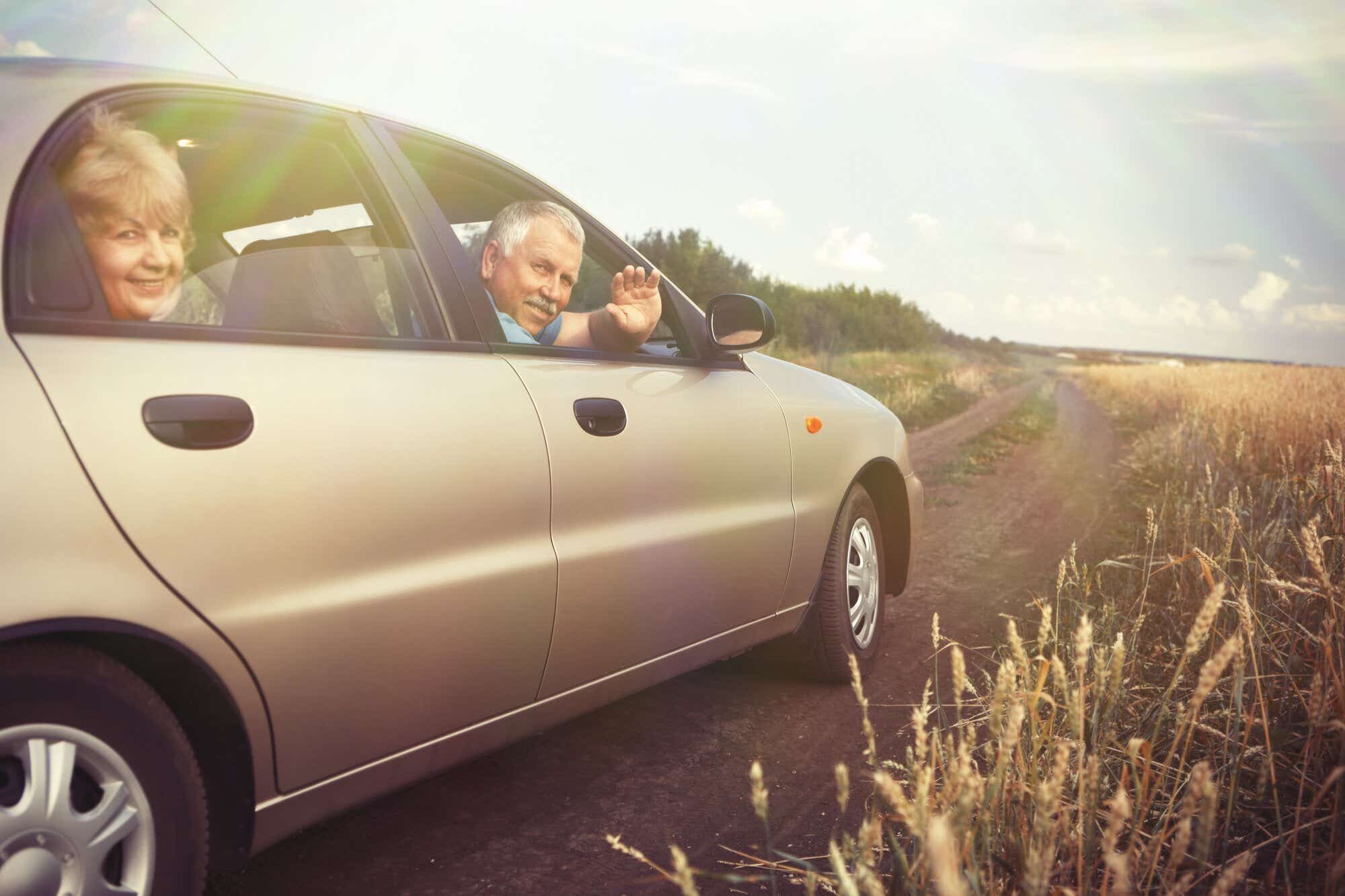 Couple driving through countryside in their car, smiling out of the window