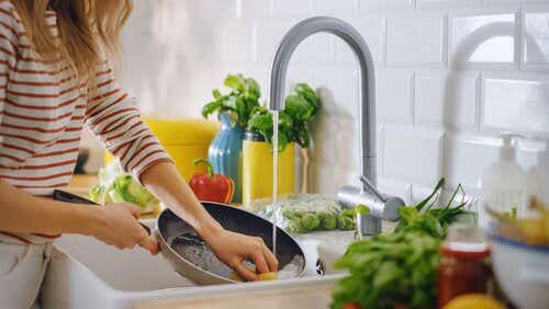 Person washing up dishes by hand in sink