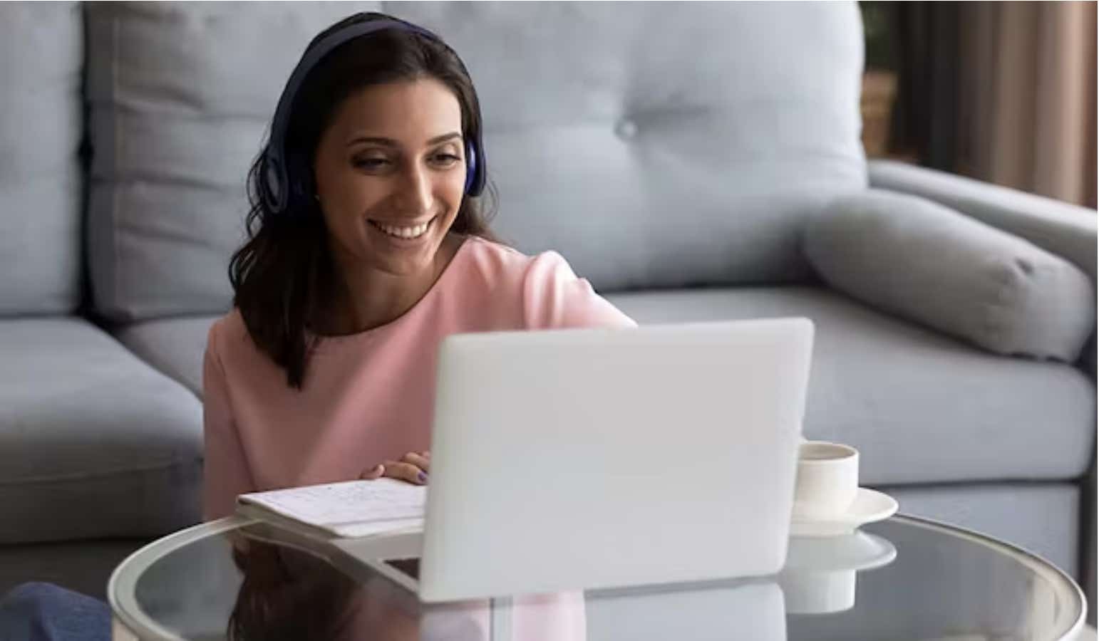 woman smiling at laptop enjoying ultrafast broadband speeds