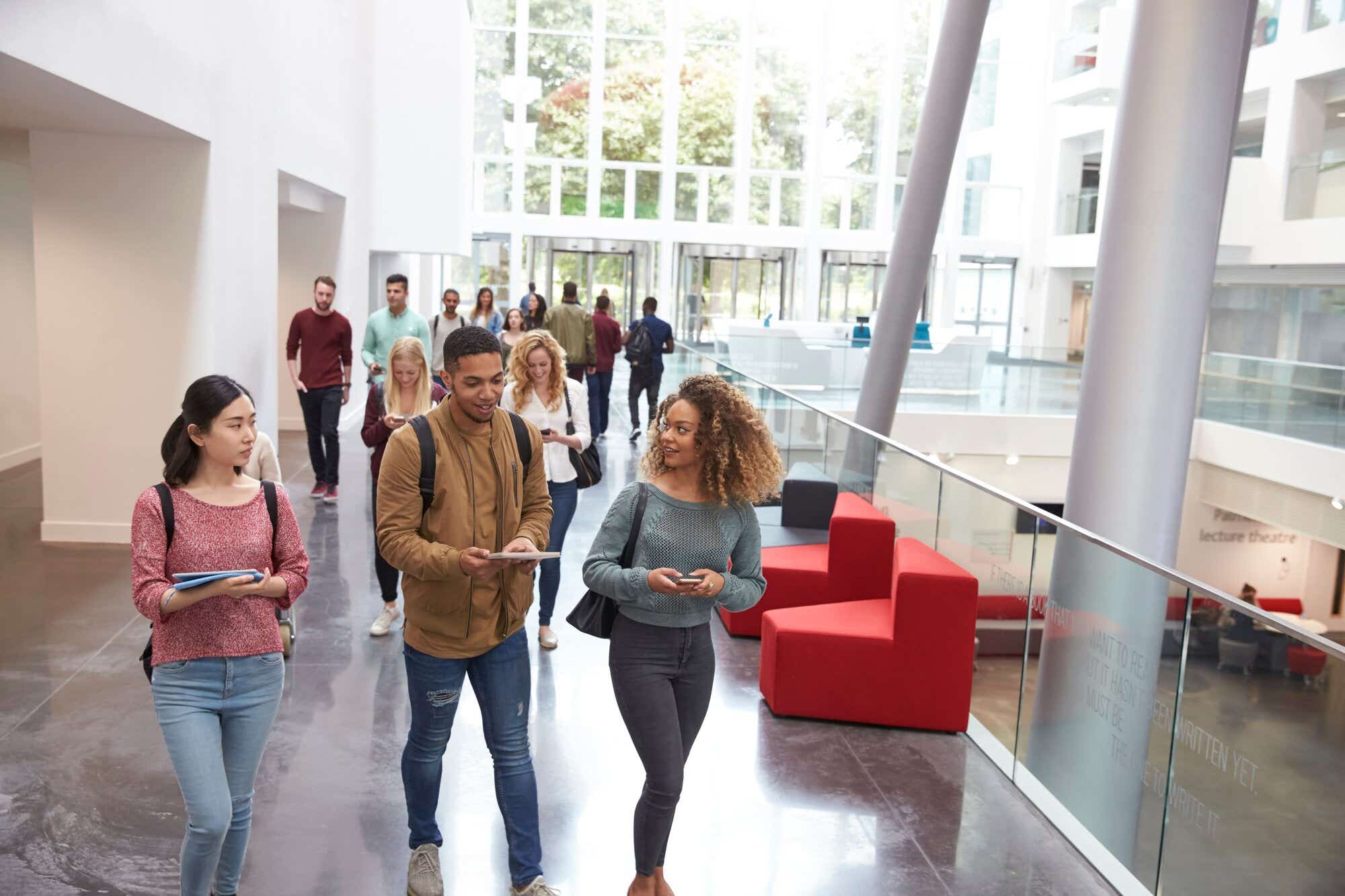 Students walk and talk using mobile devices in university