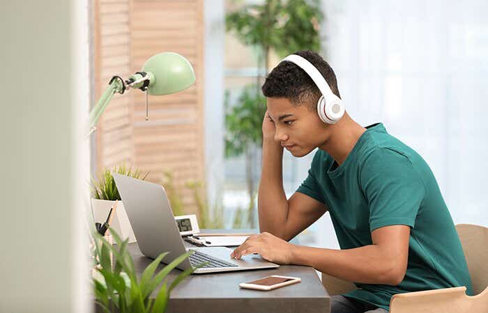 teenager watching a tv show on his laptop