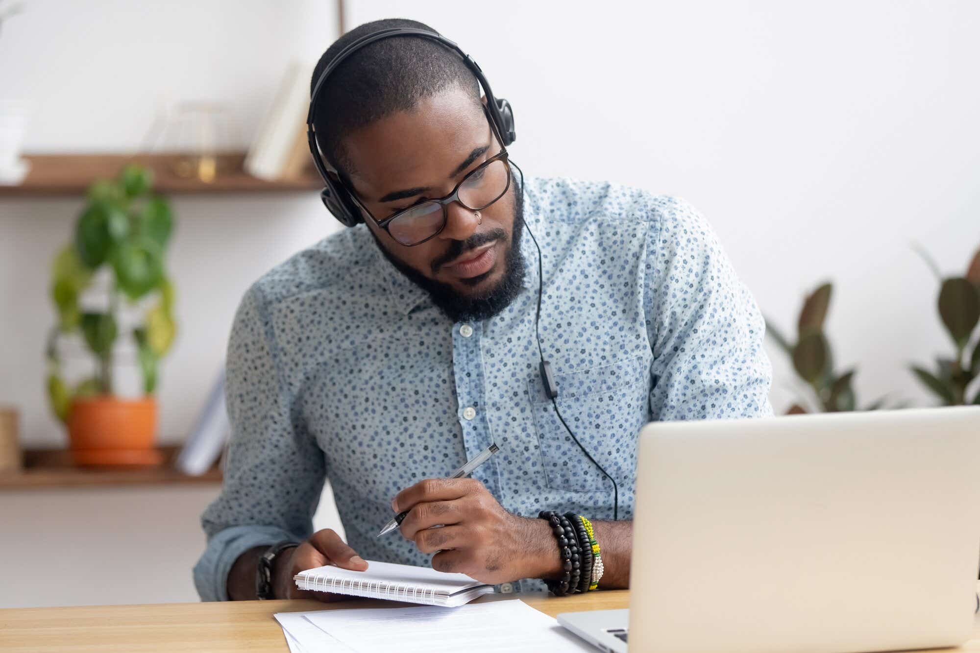 Man taking notes on work call 