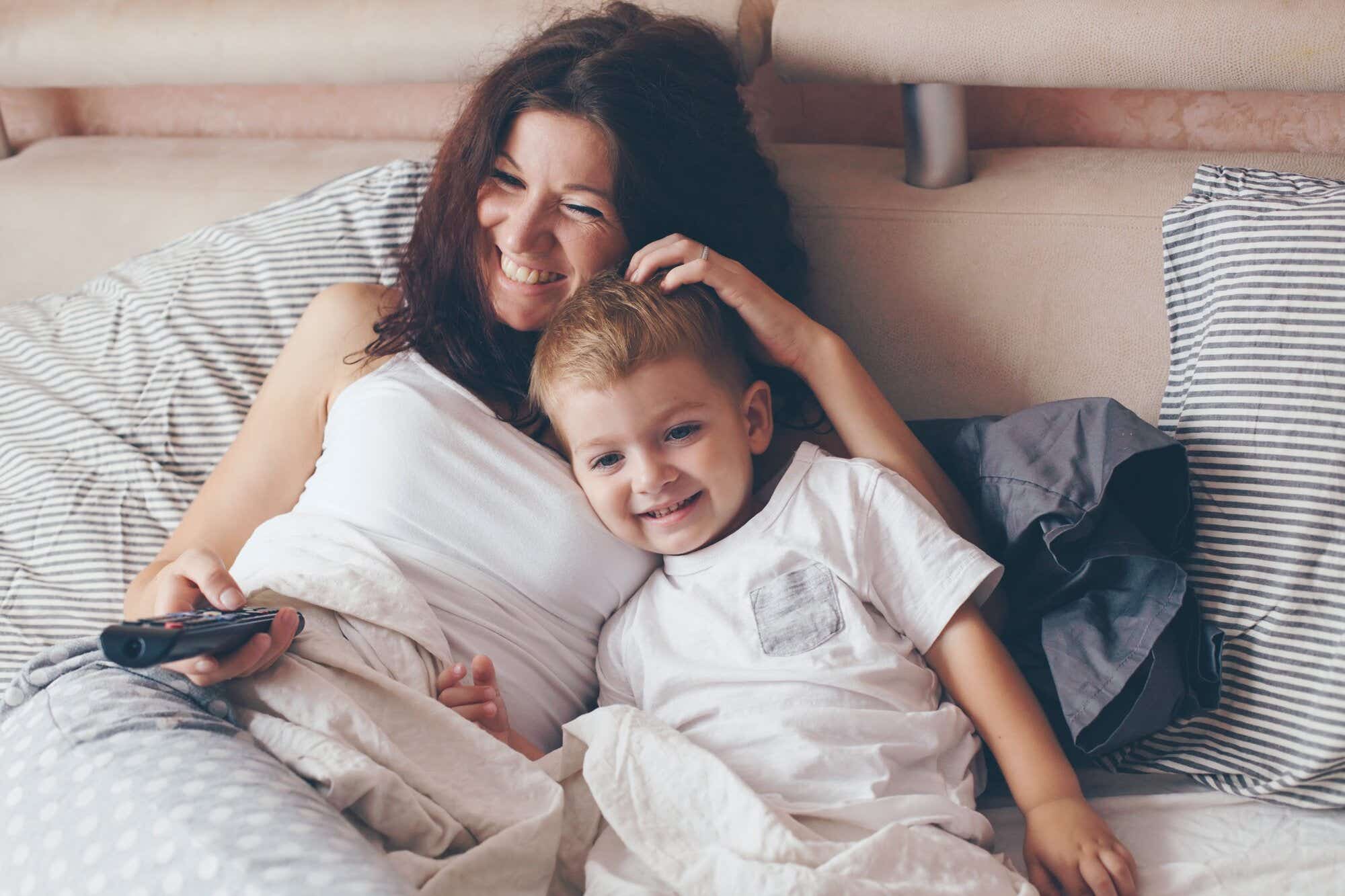 mother and son laughing while watching something on TV