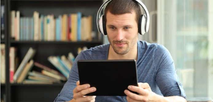 Man with headphones look at an android tablet