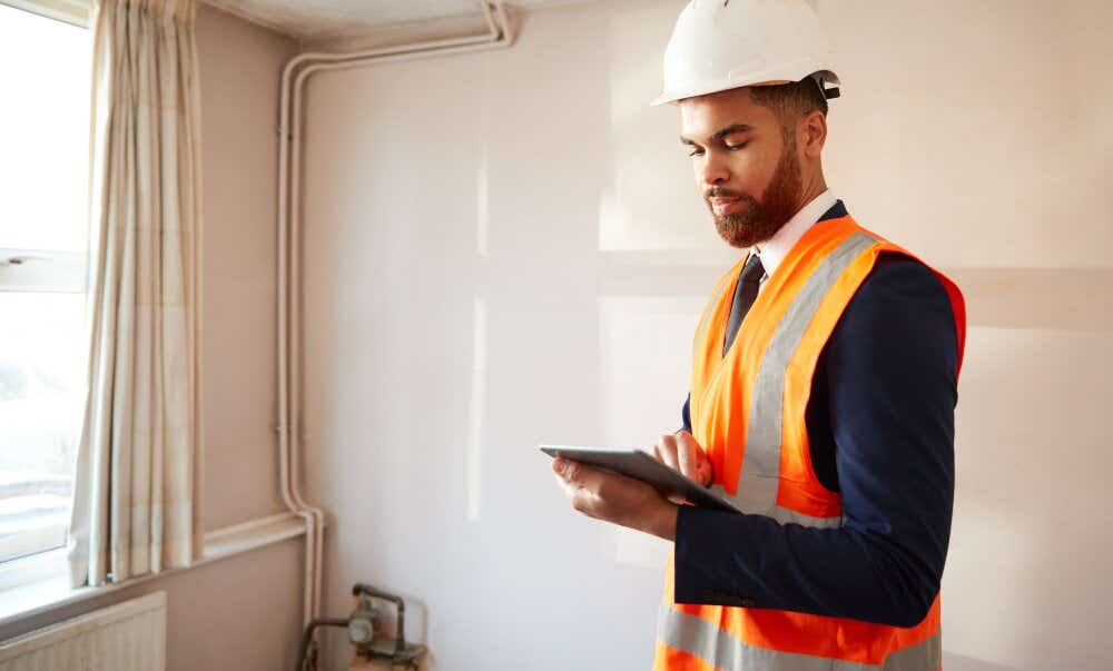 An image of a surveyor reviewing a room in a house.
