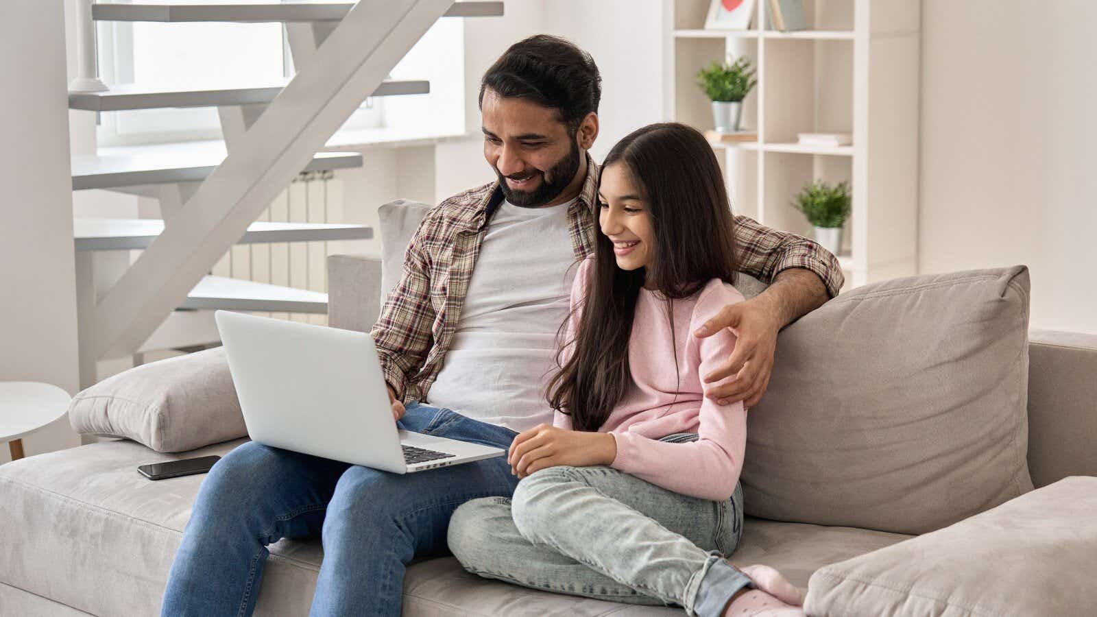 Asian family watching international tv on laptop