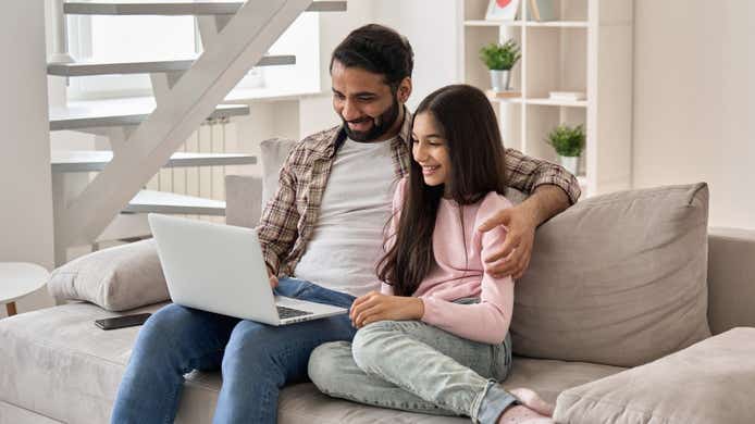 Asian family watching international tv on laptop