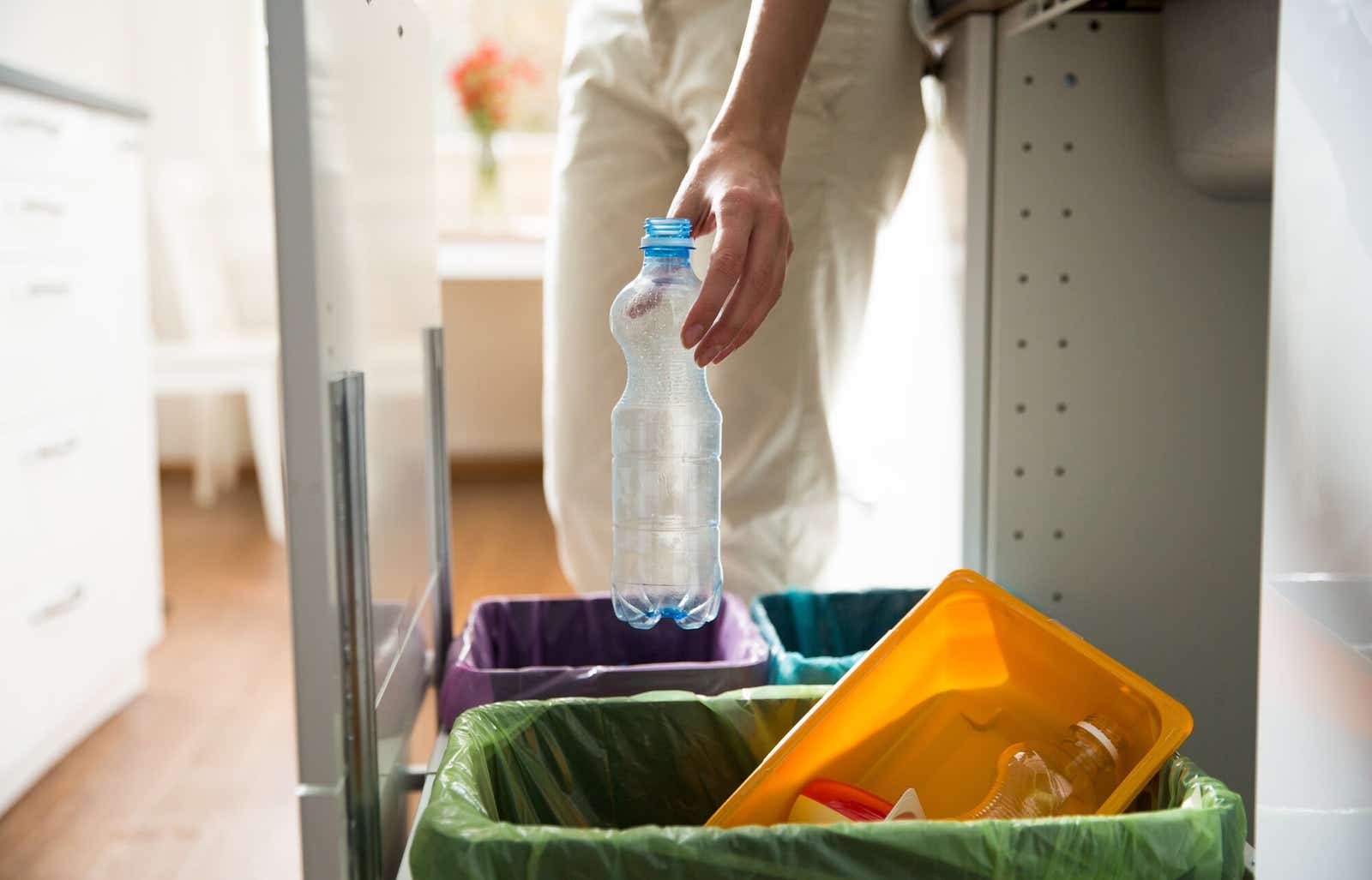 Man recycling plastic bottle at home.