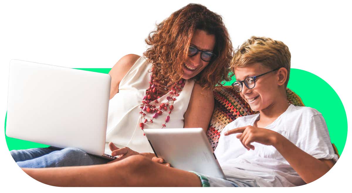 An image of a mother and son chatting. The mother is on a laptop, and the young boy is on an iPad tablet.