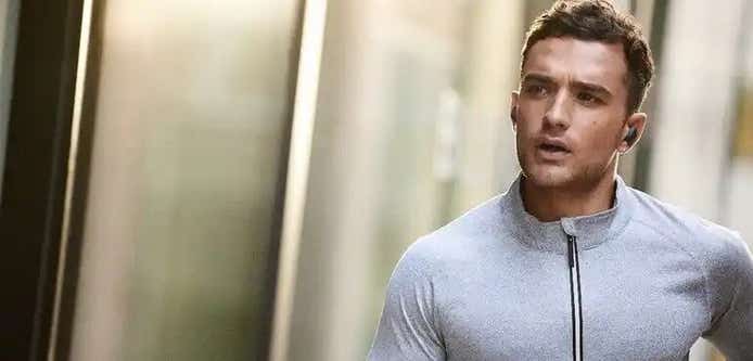 man running fitness tracker and headphones