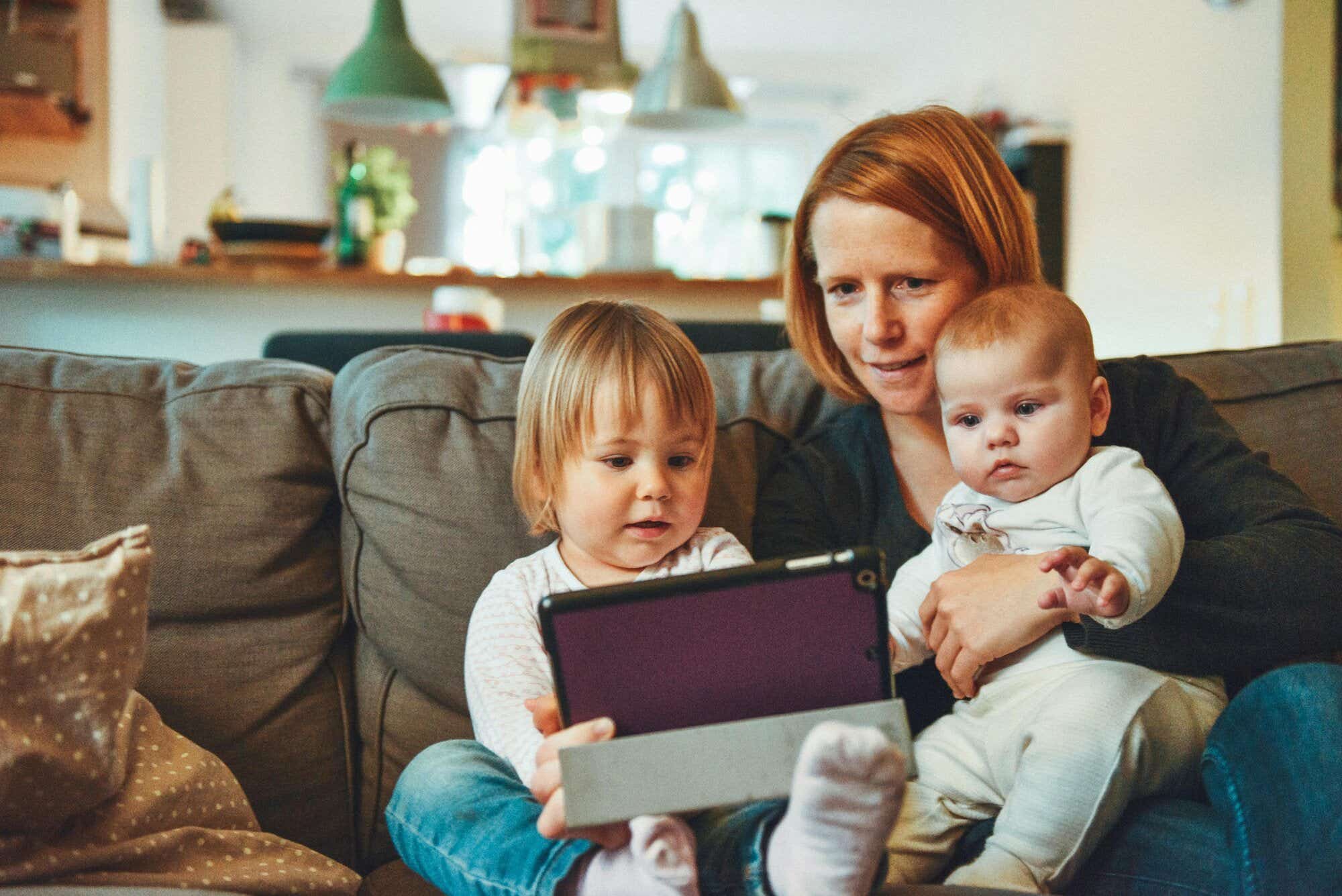 mother and children watching tablet on the sofa