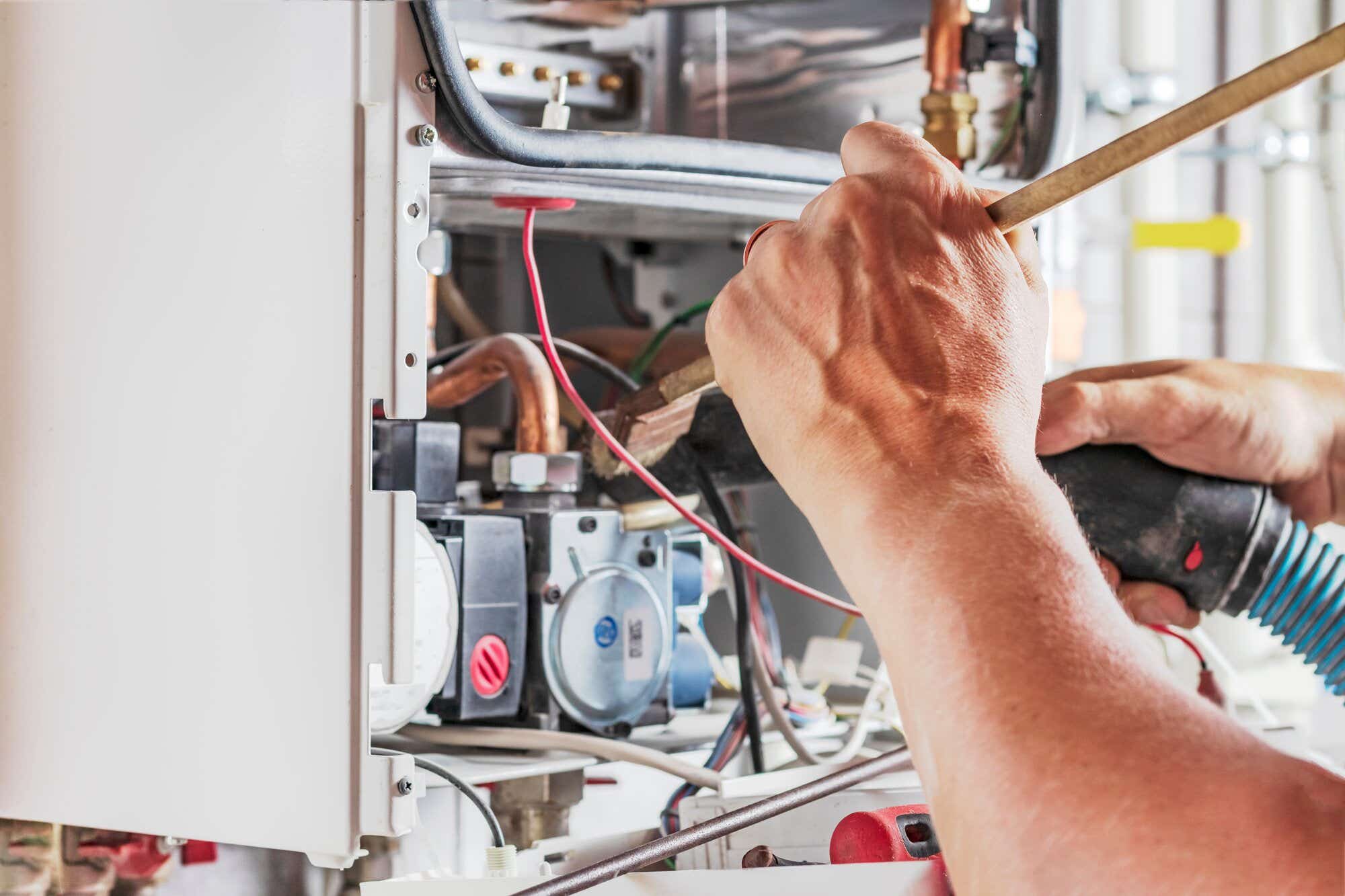 Person repairing old boiler controls