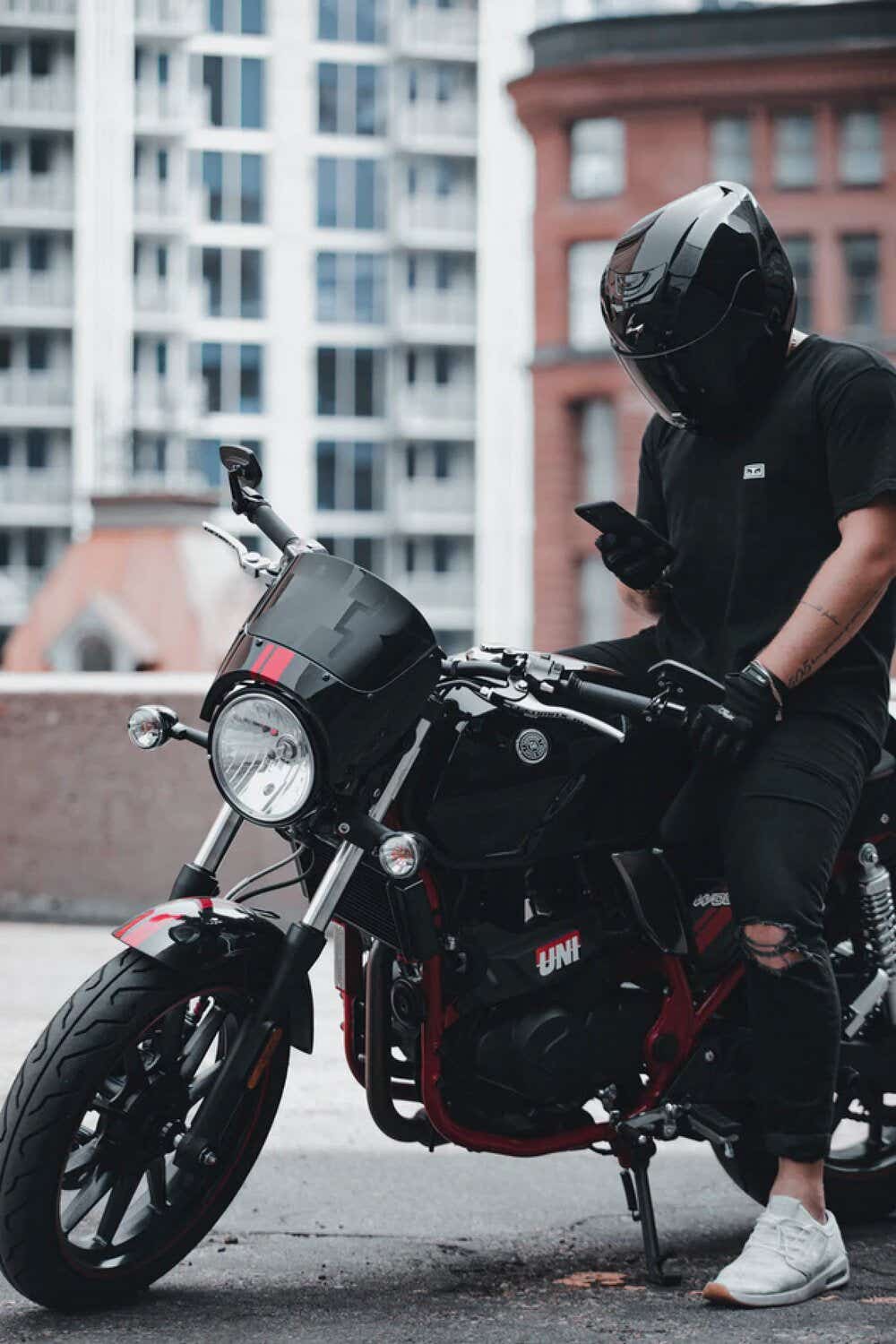 Man sat on motorbike looking at phone