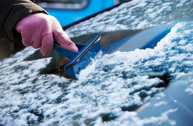Invierno raspando hielo del parabrisas