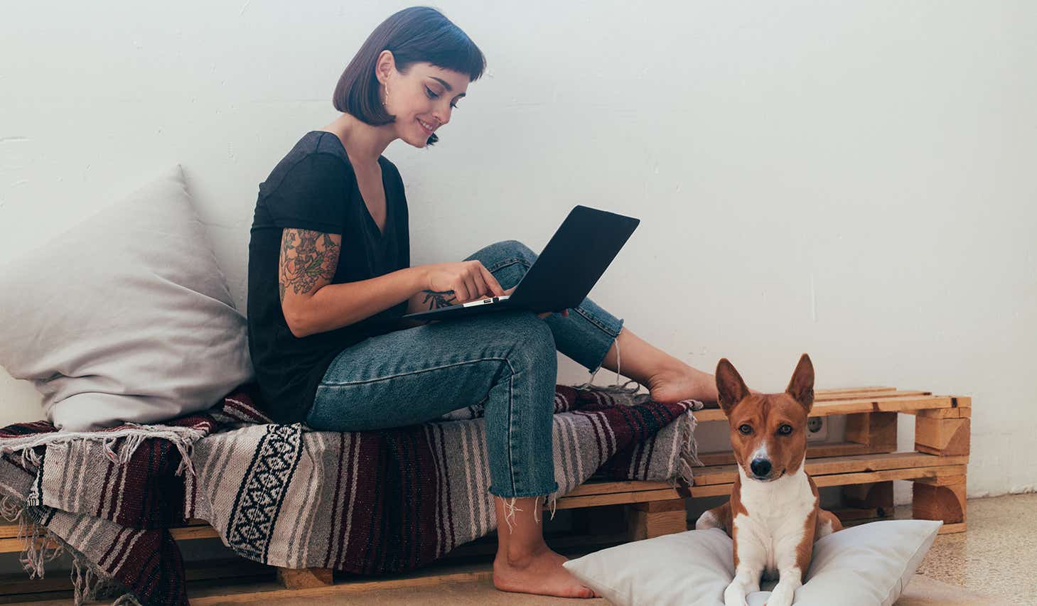 woman working on her laptop at home with her dog