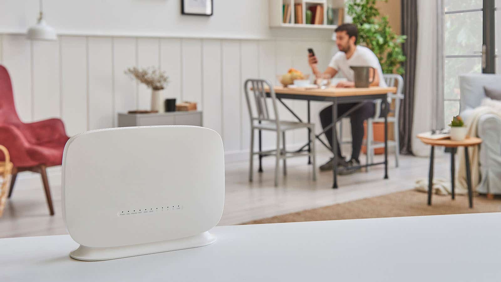a wireless router with a man using the internet behind it