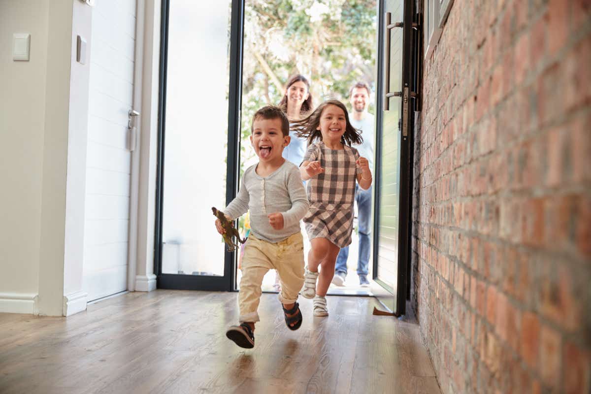 Child running through the front door of new home ahead of his family