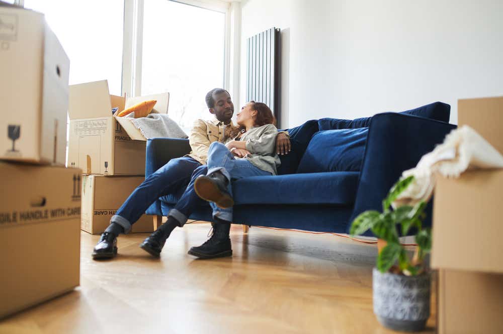 Young couple surrounded by boxes after porting their mortgage