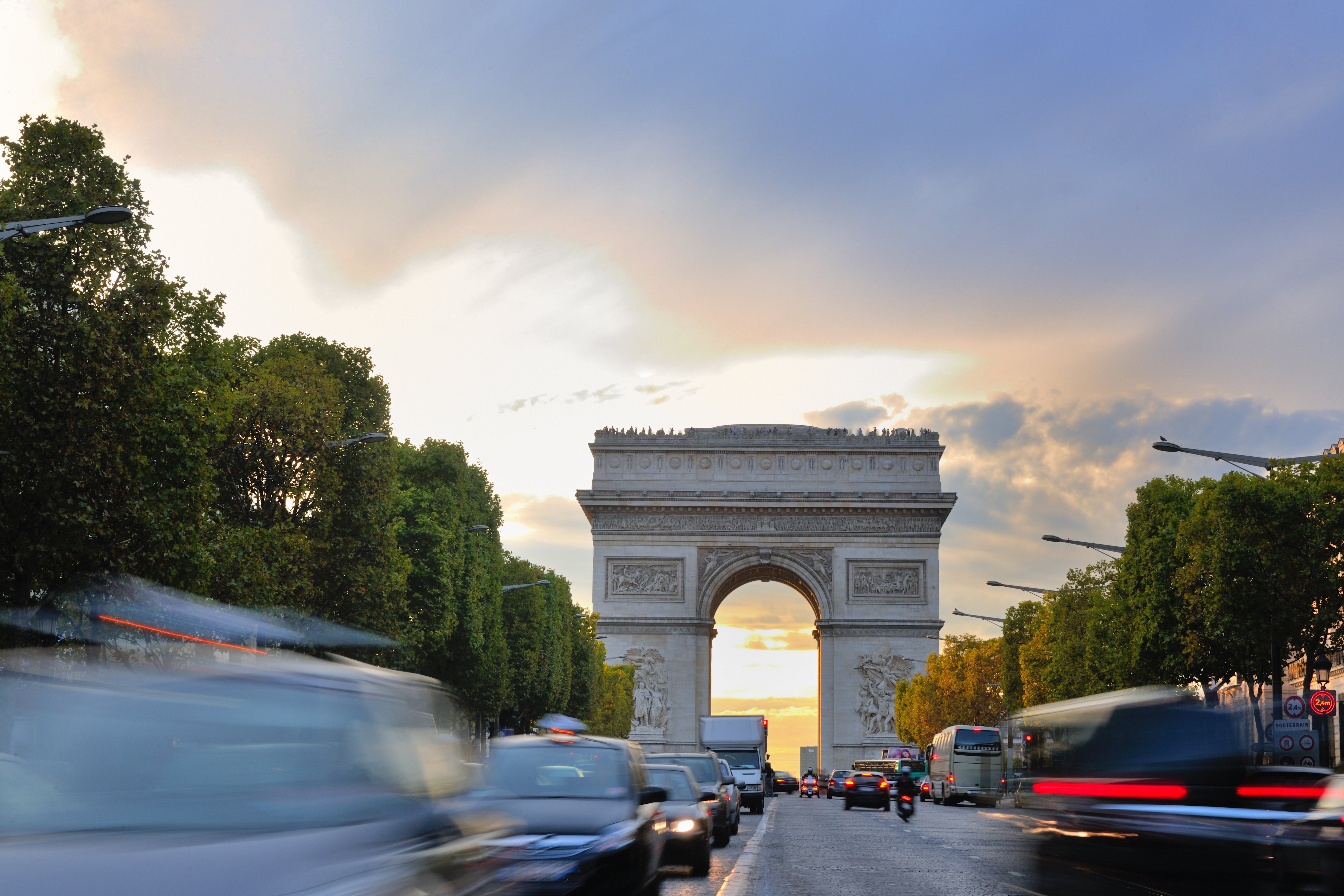 Hermosa vista nocturna con tráfico de automóviles y prisa en la noche del Arco del Triunfo en París, Francia.