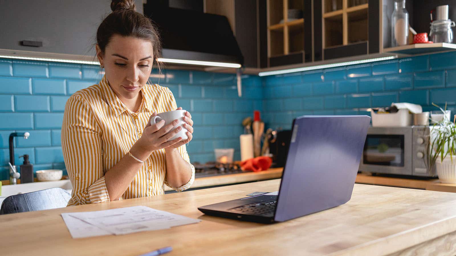 woman sat at her kitchen table looking at her bills
