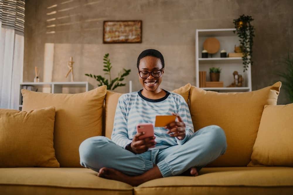 Woman using a credit card on a sofa