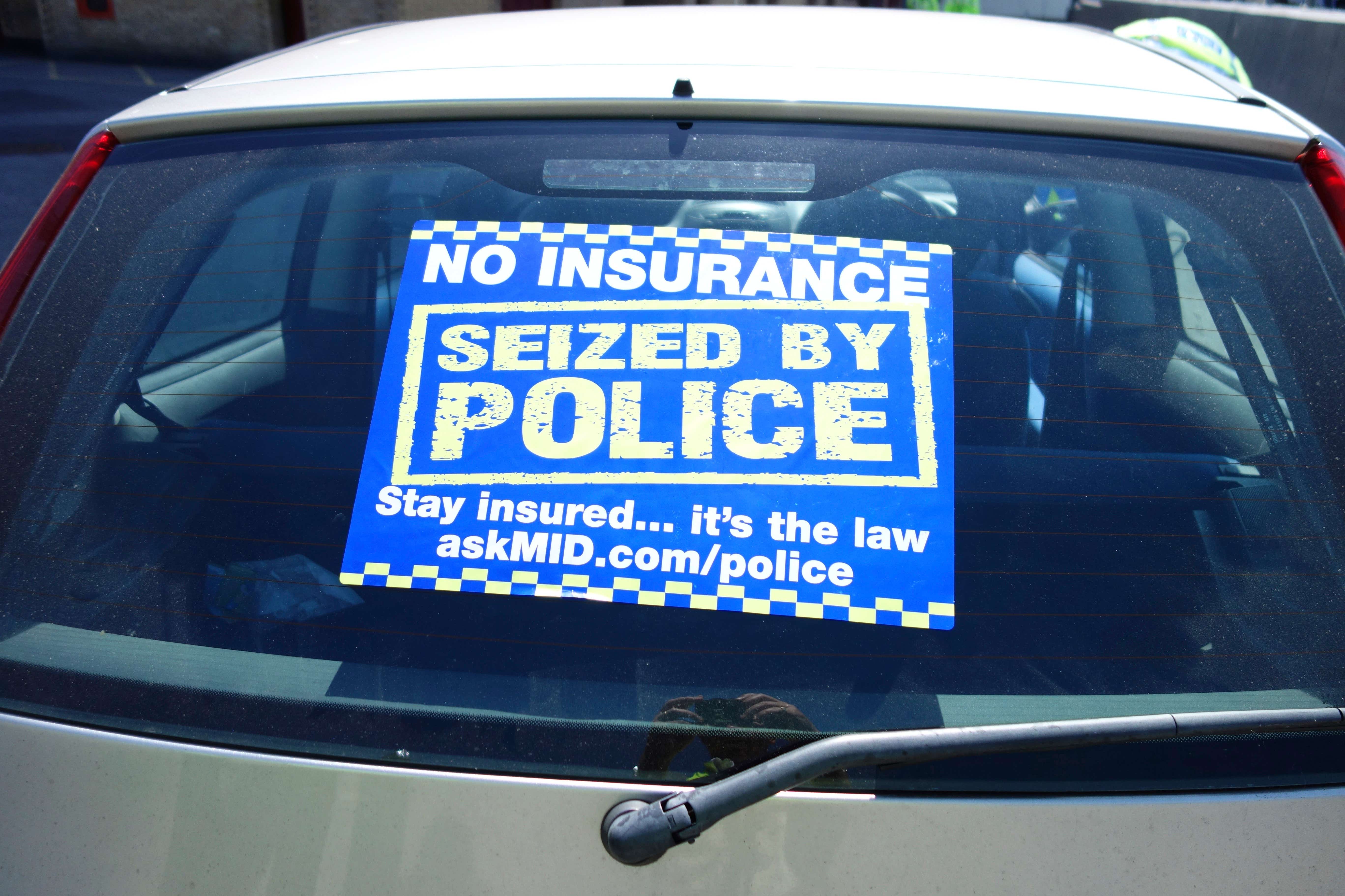 Police no-insurance seizure notice on a car's back window. 