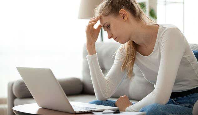 woman looking frustrated at her laptop