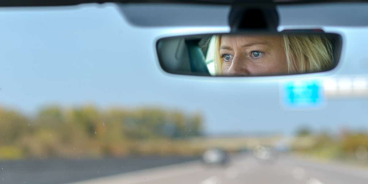 Driver seen through rear view mirror
