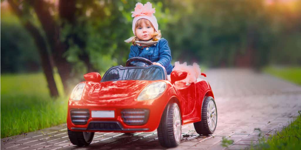 Young girl driving red car 