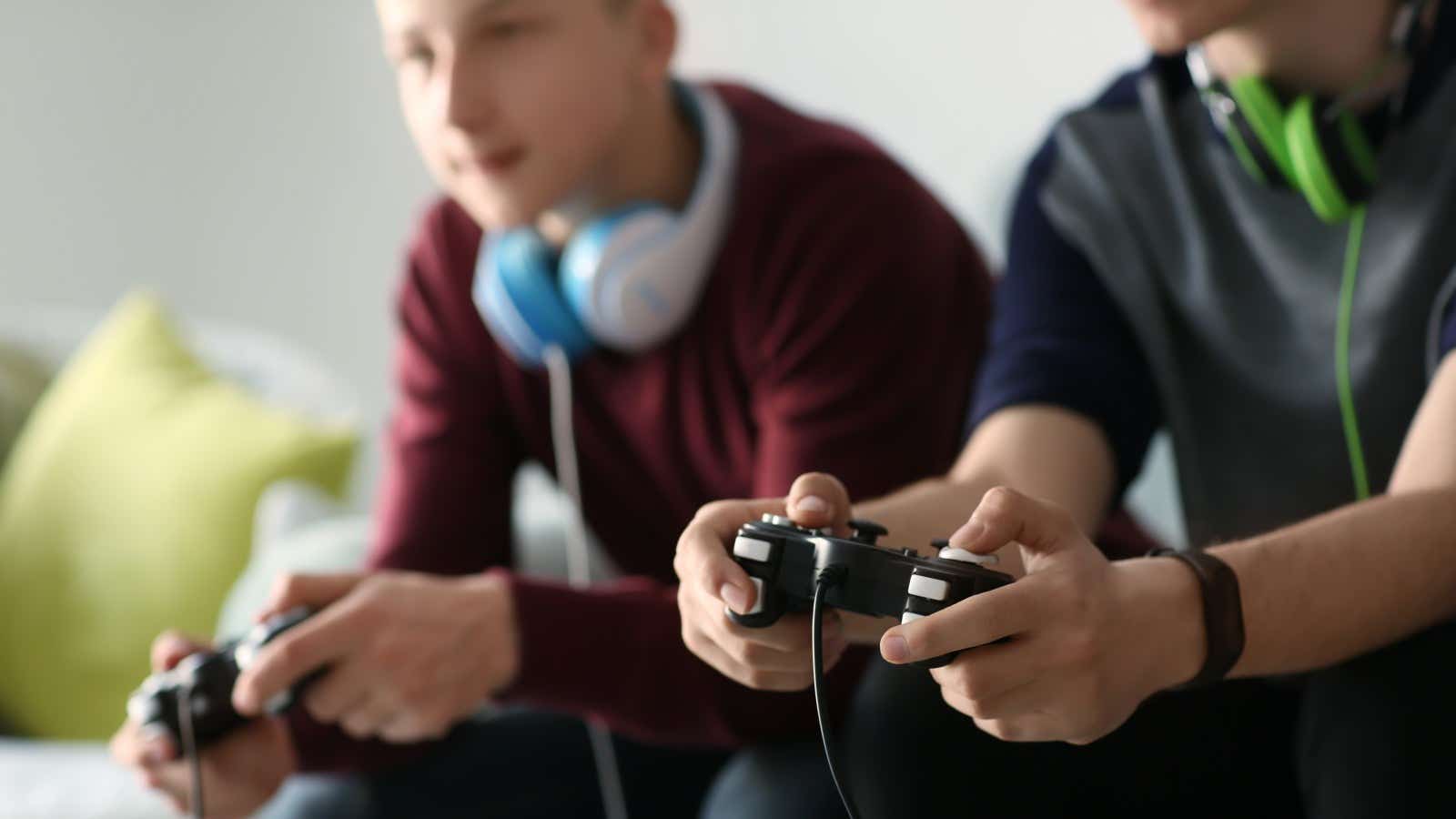 two teenagers playing video games on a gaming console